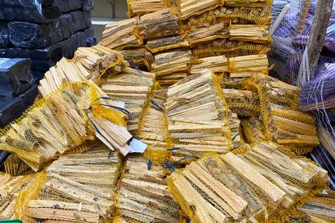 Lots of firewood in mesh bags, solid fuel for the fireplace Foto stock