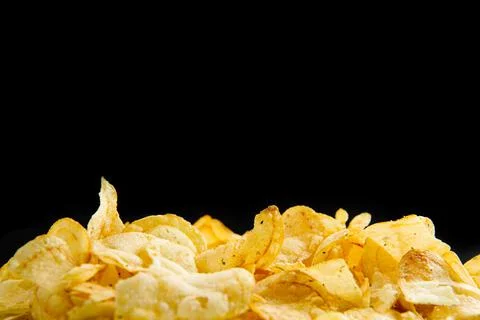 Lots of fried chips on a black background. Isolate. A place to write text. Copy Foto stock