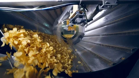 Lots of fried chips sorted in a factory machine, getting mixed with flavor Stock Footage 105596899