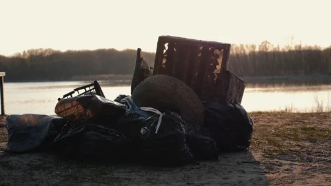 Lots of garbage, old stuff, on the beach at sunset. Environmental pollution. Video stock 114159040