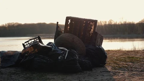Lots of garbage, old stuff, on the beach at sunset. Environmental pollution. Video stock 114798117