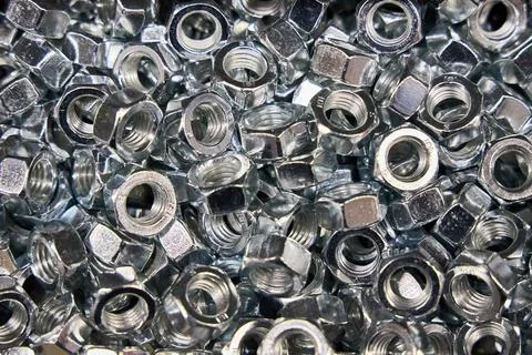 Lots of Hex Nuts fasteners selective focus background. Close up view of shi.. Stock Photos