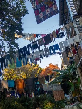 Lots of laundry hanging in the yard. Drying clothes outdoors. Stock Photos