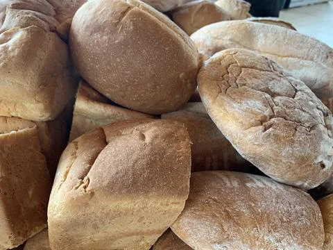Lots of loaves of bread on the table. Concept: baking wheat to help people. B Stock Photos