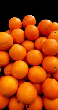 Lots of oranges on black background. Stock Photos