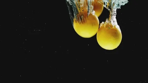 Lots of oranges falling into water in slow motion Video stock 75405026