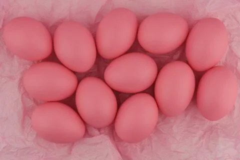 Lots of pink painted Easter eggs on crumpled pink wrapping paper. Foto stock