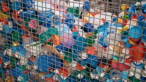 Lots of plastic bottle caps in an iron cage to collect plastic. The concept of Stock Footage 120421373