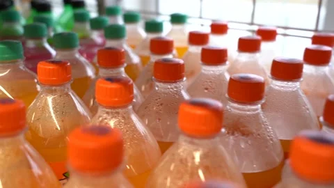 Lots of plastic drinks bottles in the shop by the window. CLOSE-UP. Row of Stock Footage 143972238