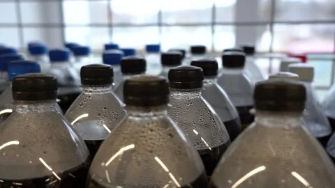 Lots of plastic drinks bottles in the shop by the window. CLOSE-UP. Row of Stock Footage 143972410