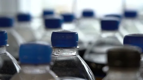 Lots of plastic drinks bottles in the shop by the window. CLOSE-UP. Row of Stock Footage 143972596