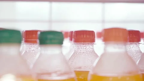 Lots of plastic drinks bottles in the shop by the window. CLOSE-UP. Row of Stock Footage 144680880