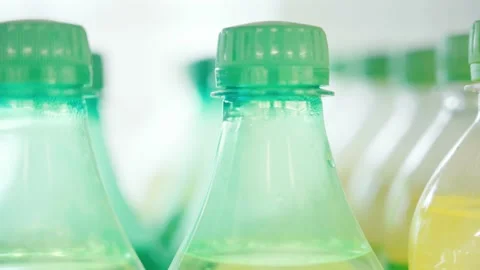 Lots of plastic drinks bottles in the shop by the window. CLOSE-UP. Row of Stock Footage 144681042
