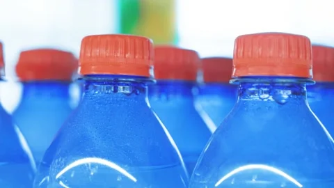 Lots of plastic drinks bottles in the shop by the window. CLOSE-UP. Row of Stock Footage 144881467