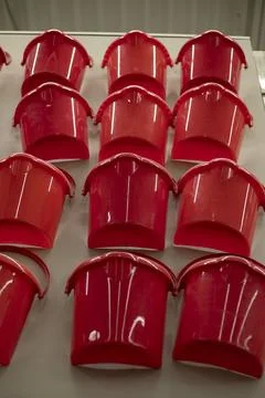 Lots of red buckets. Plastic buckets in the store. Sale of home equipment. Stock Photos