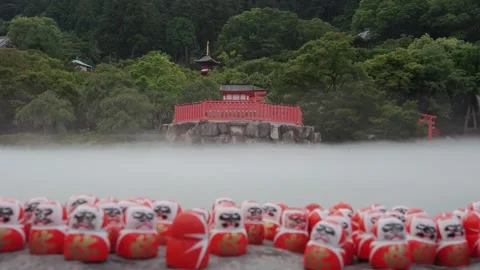 Lots of red Daruma dolls placed on stone platform at Katsuoji Temple in Osaka Stock Footage 345188154