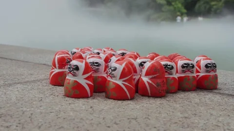Lots of red Daruma dolls rest on stone platform at Katsuoji Temple in Osaka Stock Footage 344282239