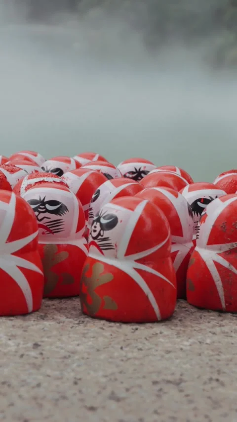 Lots of red Daruma dolls rest on stone platform at Katsuoji Temple in Osaka Stock Footage 345740847