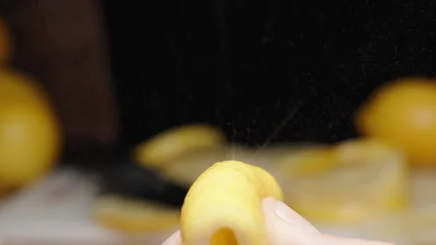 Lots of Sliced Lemon in the background. I squeeze a lemon peel in my hand and th Stock Footage 234204348