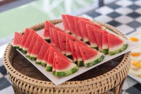 Lots of small triangular slices of ripe red watermelon on a plate Fotos Stock