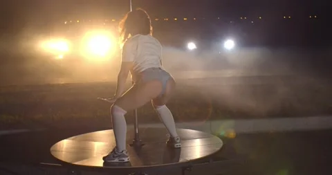 Lots of smoke is flying in the background of a young woman twerking outdoors, 4k Stock-Footage 138539646