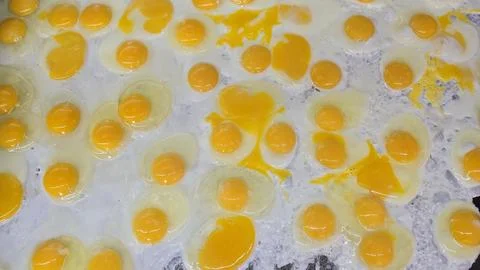 Lots of Sunny Side Up Fried Eggs Cooking at the grill Together For Breakfas.. Stock Photos