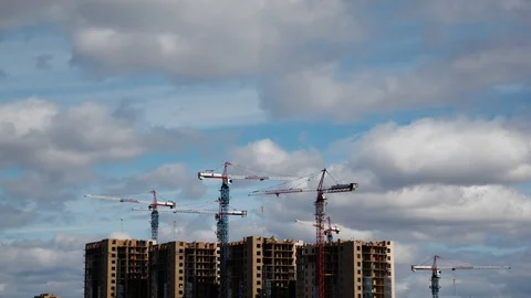 Lots of tall construction cranes. Sky and clouds in the background.  Stock Footage 108648148