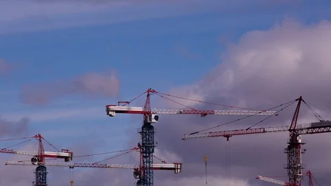 Lots of tall construction cranes. Sky and clouds in the background.  Video stock 108648207