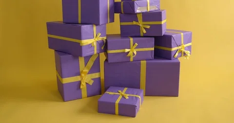 Lots of violet gift packages on yellow background Stock Footage 129153182