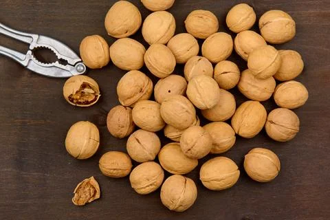 Lots of walnuts and nutcracker close up on wood background Stock Photos