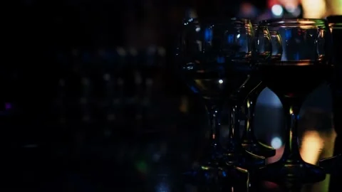 Lots of wine glasses and drinks on the table in a dark club, Stock Footage 222488330