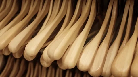 Lots of wooden empty hangers on a rack in a store. Minimalist home storage Stock Footage 320971580