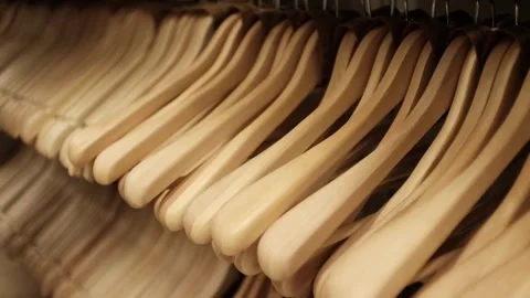 Lots of wooden empty hangers on a rack in a store. Minimalist home storage Stock Footage 320971873
