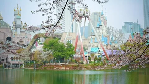 Lotte World Adventure Surrounded by Sakura Trees Across Seokchon Lake in Seou Stock Footage 336838869