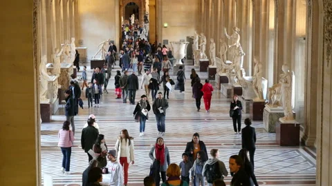 The Louvre museum and its interior hall with antic white sculptures and tourists Stock Footage