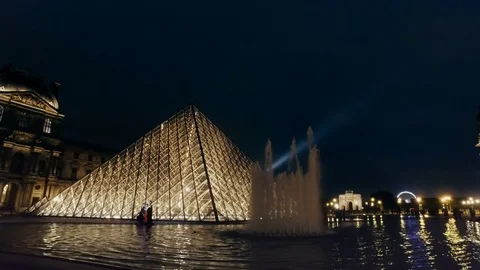 The Louvre pyramid at night and Eiffel tower light at backgorund Stock Footage