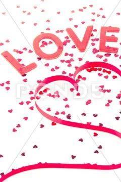 Love and heart shaped ribbon with pink confetti Stock Photos