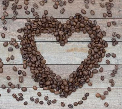 Love Coffee flat lay: an empty heart with coffee beans on a wooden background Fotos de archivo