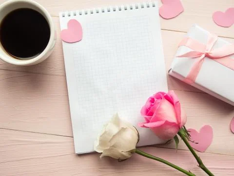 Love composition - coffee cup, gift box and roses on pink background, top vie Foto stock