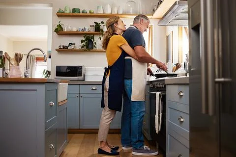 Love, food and elderly couple cooking in a kitchen, hug and bond while preparing Stock Photos