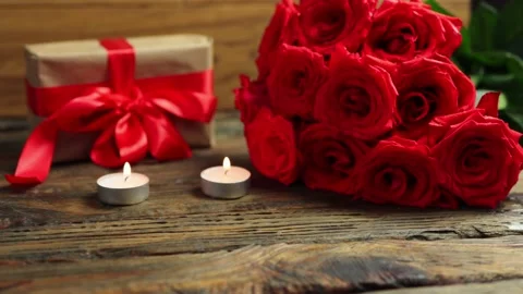 Love gift box bunch red roses burning candles on wooden table Valentine's Day 動画素材 166560208