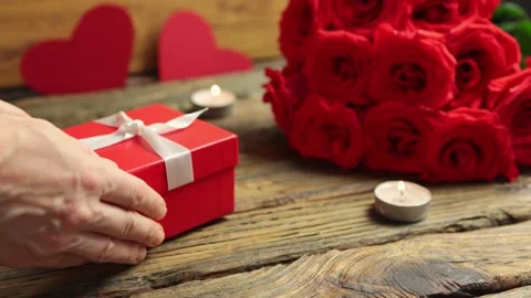 Love gift box bunch red roses burning candles on wooden table Valentine's Day 库存影片 166560262