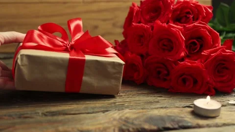 Love gift box bunch red roses burning candles on wooden table Valentine's Day Stock Footage 168331961