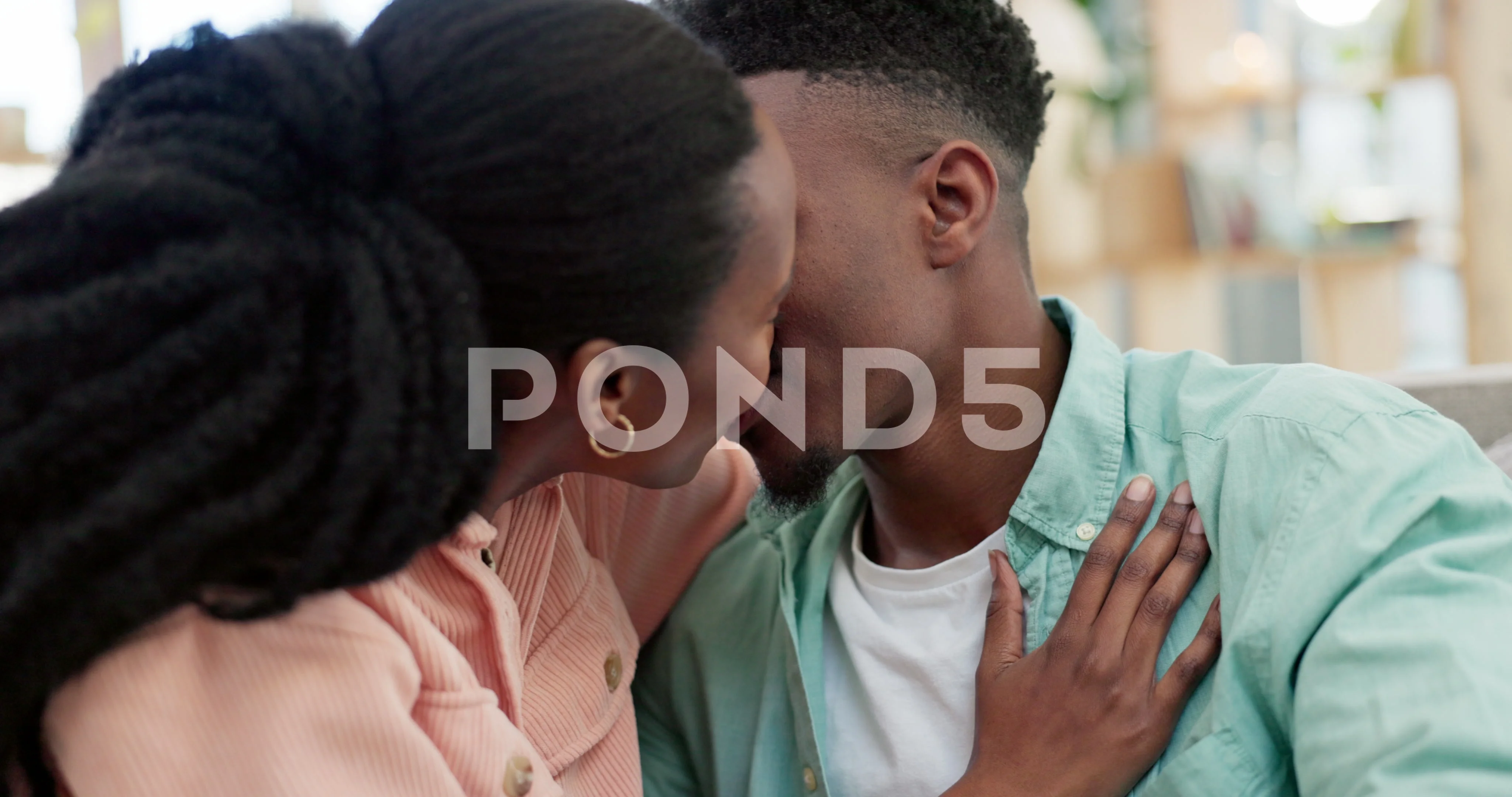 Love, happy and black couple kissing on a sofa in the living room for  relaxing