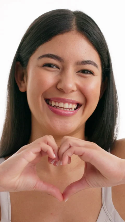 Love, heart hands and face of woman in studio for romance, positive and kindness Stock Footage 333690896