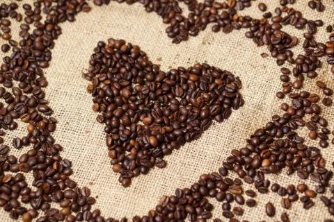 Love heart made of coffee beans on sackcloth Stock Photos
