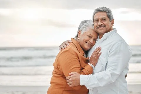 Love, hug and portrait of old couple on beach for romance, bonding and travel Stock Photos