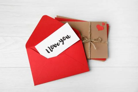 Love letter and stack of envelopes on white wooden background, flat lay Foto stock