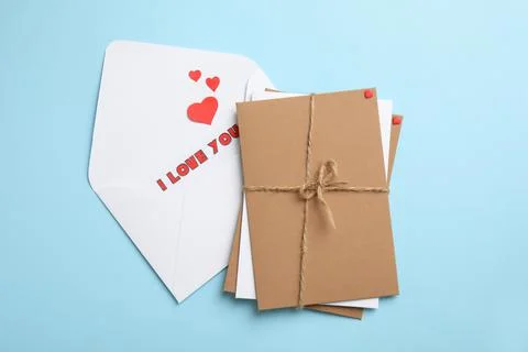 Love letter and stack of envelopes on light blue background, flat lay Foto stock