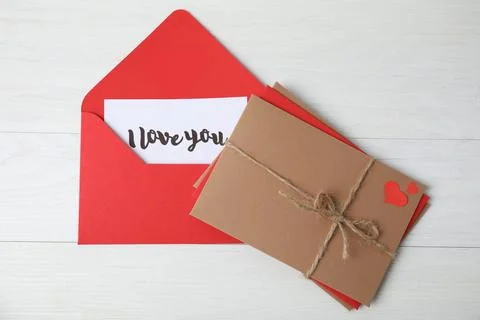 Love letter and stack of envelopes on white wooden background, flat lay Foto stock